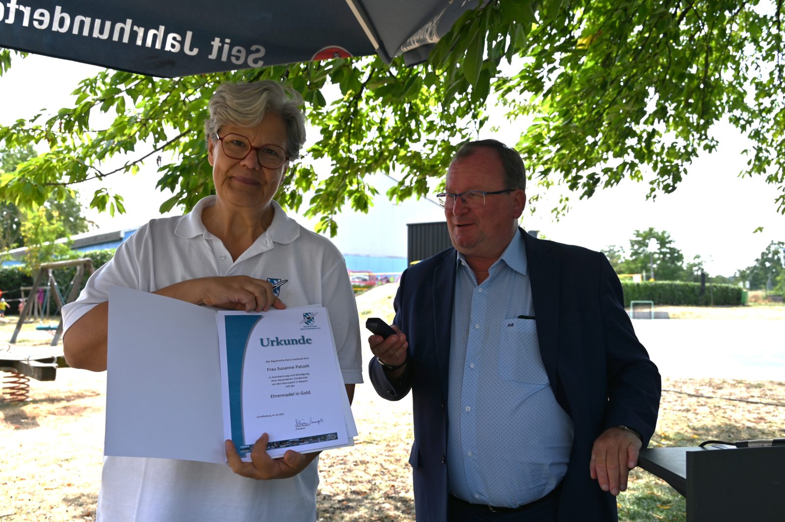 Für ihre Verdienste um den Kanusport ehrt Oliver Bungers die Bezirksvorsitzende Susanne Patzelt mit der BKV-Ehrennadel in Gold.